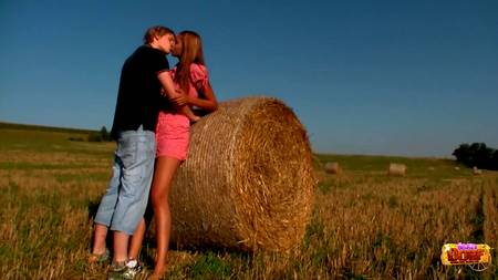 Парень развлекается с подружкой около стога сена