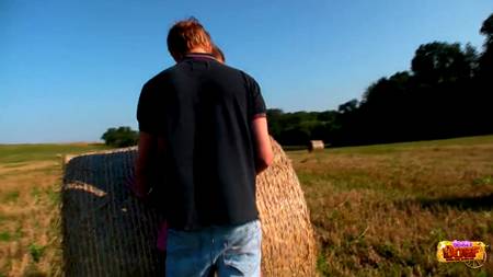 Парень развлекается с подружкой около стога сена