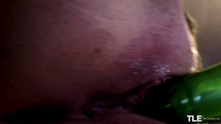 Пышногрудая нимфа трахает себя в туалете пивной бутылкой