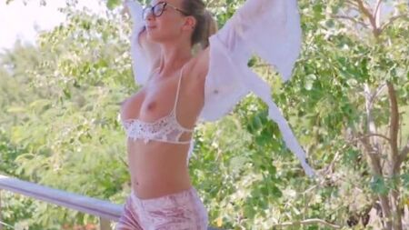 Стройная девушка эротично ласкает себя руками на улице