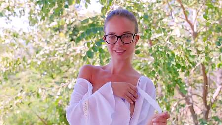 Стройная девушка эротично ласкает себя руками на улице