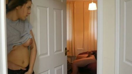 Грудастая девушка мастурбирует пизду возле комнаты дрочущего парня